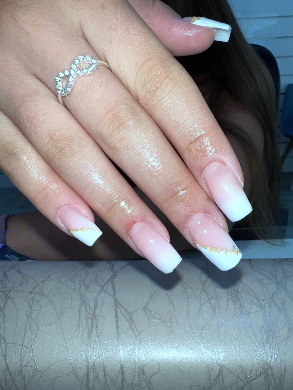 Uñas coffin largas en babyboomer, degradado rosa a blanco con una línea de pan de oro.
